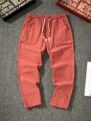 Men's red loose-fit pants with a drawstring waist and pockets.