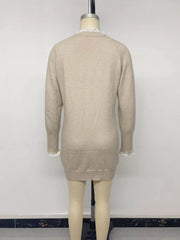 Back view of beige cable knit sweater dress on a mannequin with lace trim and raglan sleeves