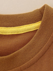 Detail view of the brown ribbed neckline with yellow inner trim on a children's t-shirt