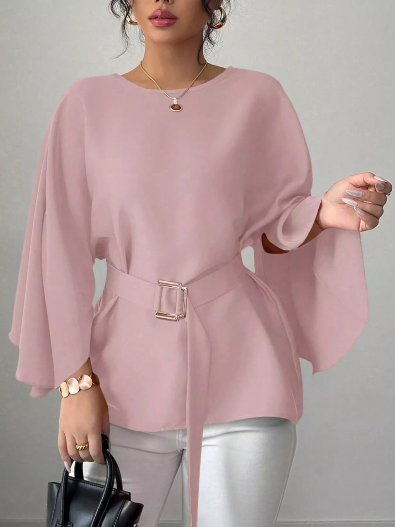 Pink batwing sleeve blouse front view with one hand raised showing wide flowing sleeve