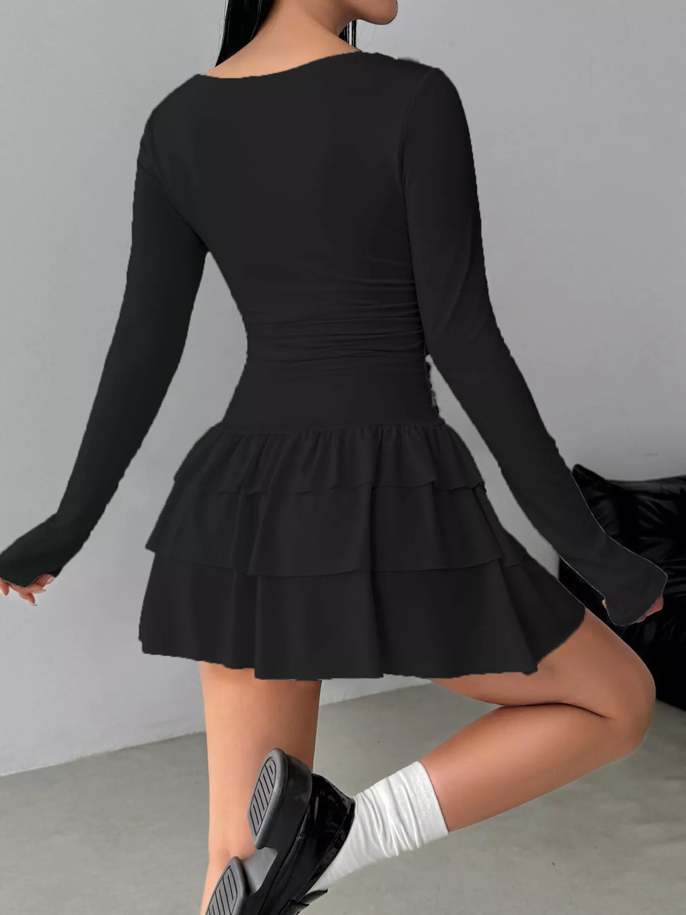 Black layered ruffle long sleeve mini dress worn from the back showing the ruched waist