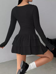 Black layered ruffle long sleeve mini dress worn from the back showing the ruched waist