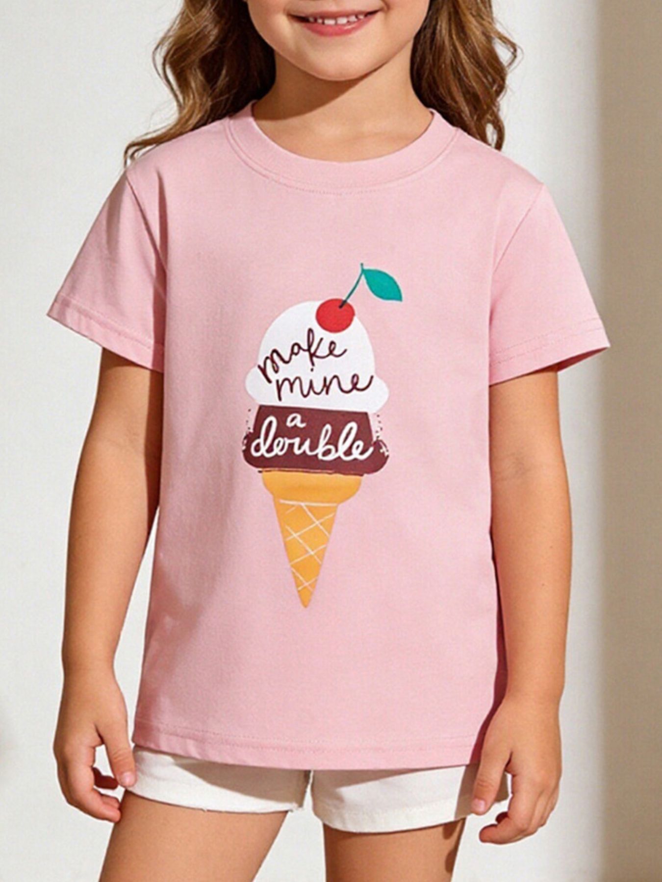 Blush pink children's short sleeve t-shirt with an ice cream cone graphic, shown worn