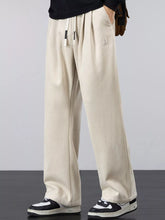 Men's khaki lightweight loose-fit pants with a drawstring waist and pockets.