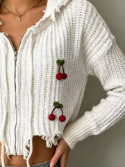 Close side view of white knit zip up sweater with red cherry appliques and ribbed cuffs