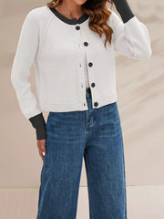 On-model side front view of the white cardigan with black trim and one arm raised