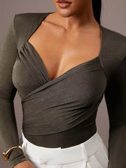 Close cropped front view of army green ruched surplice bodysuit with white trousers