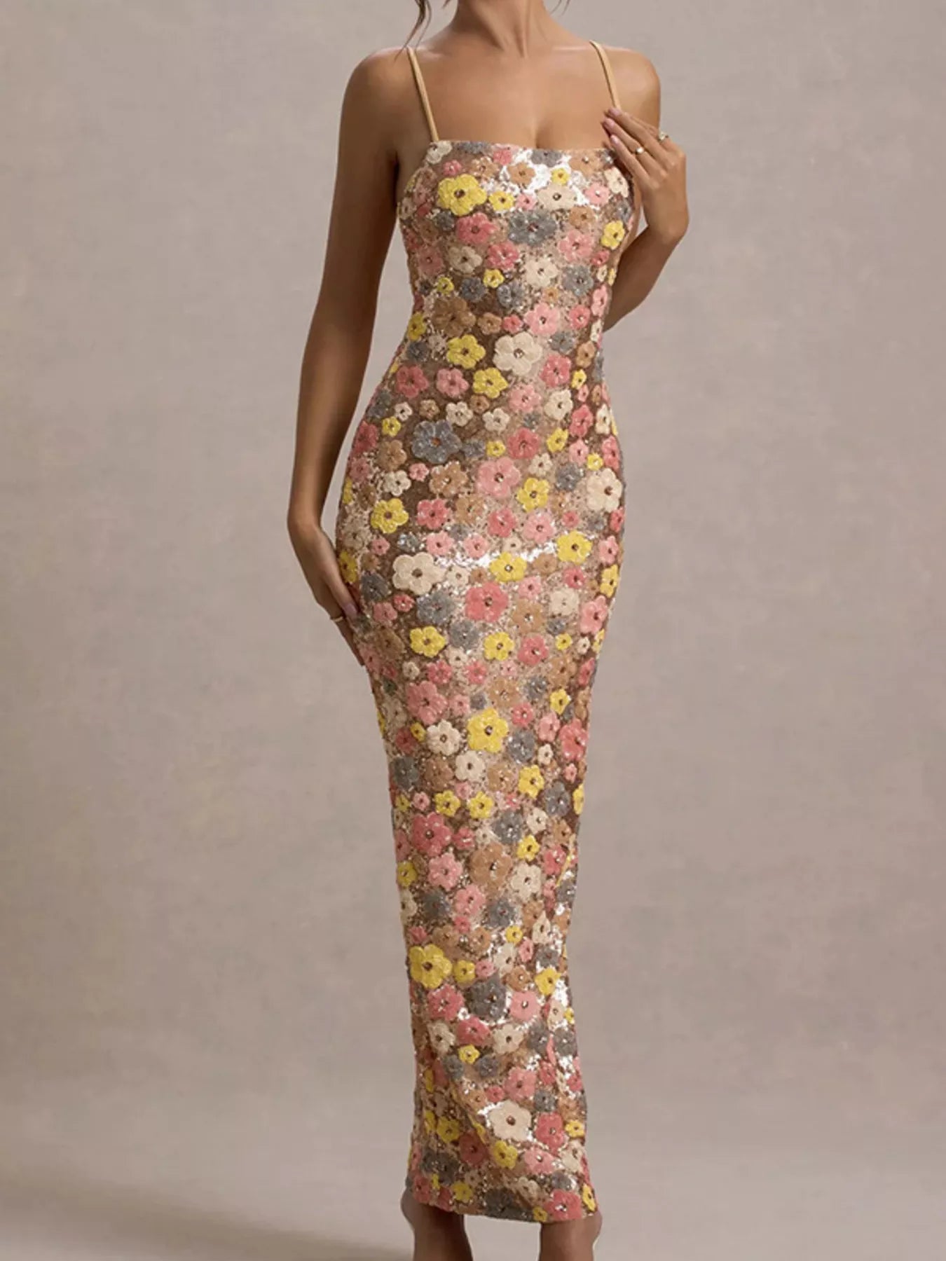 Front view of a multicolor floral sequin bodycon maxi dress with a hand near the strap