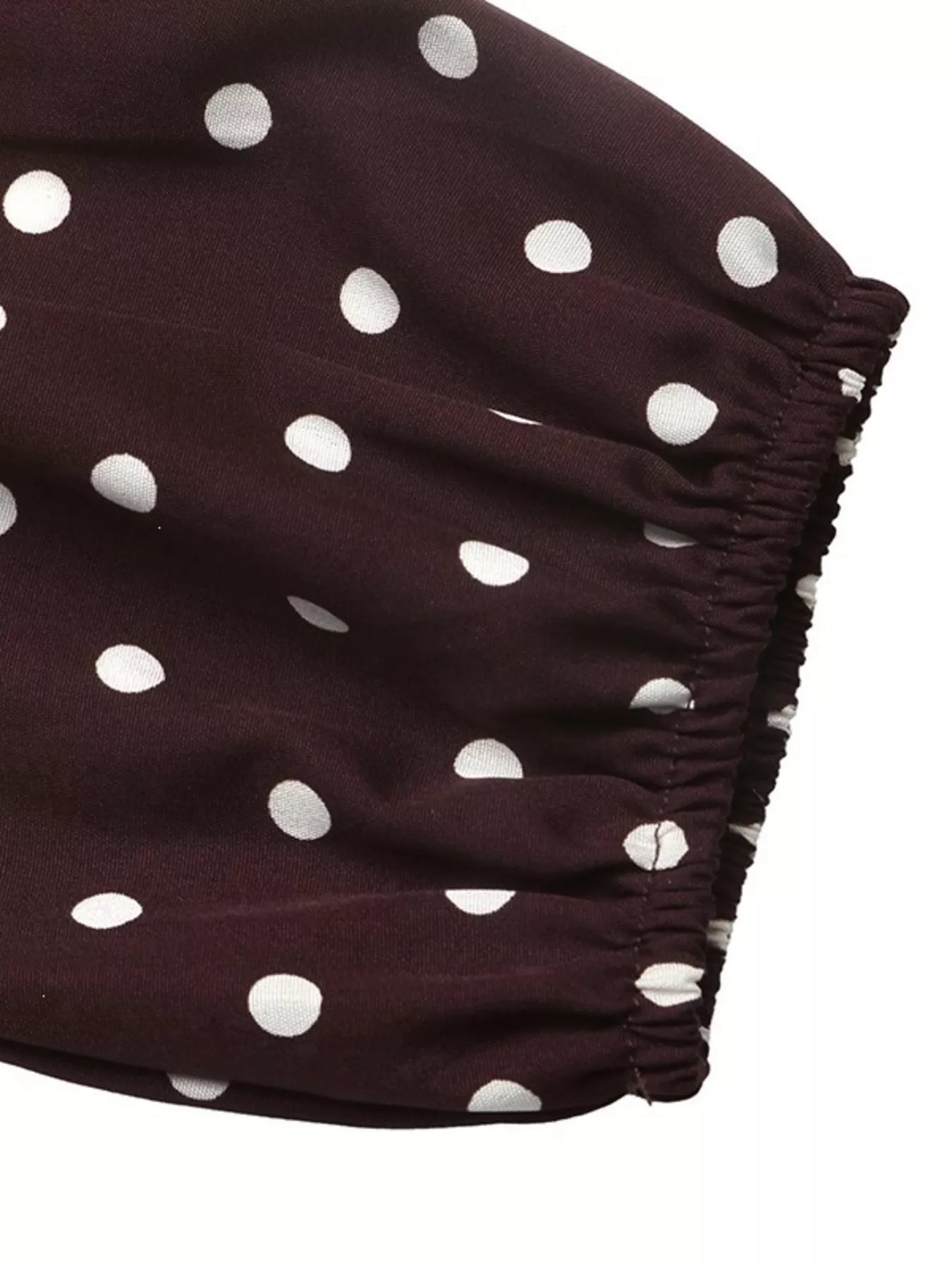 Close-up of the coffee brown polka dot bodysuit elastic sleeve cuff
