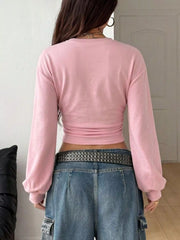 Back view of pink long sleeve cropped t shirt with wide sleeves and jeans