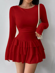 Red layered ruffle long sleeve mini dress worn front facing with a white shoulder bag