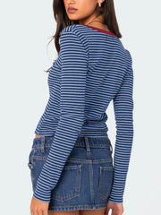 Back view of blue and navy striped long sleeve t shirt with deep red neckline trim worn on model