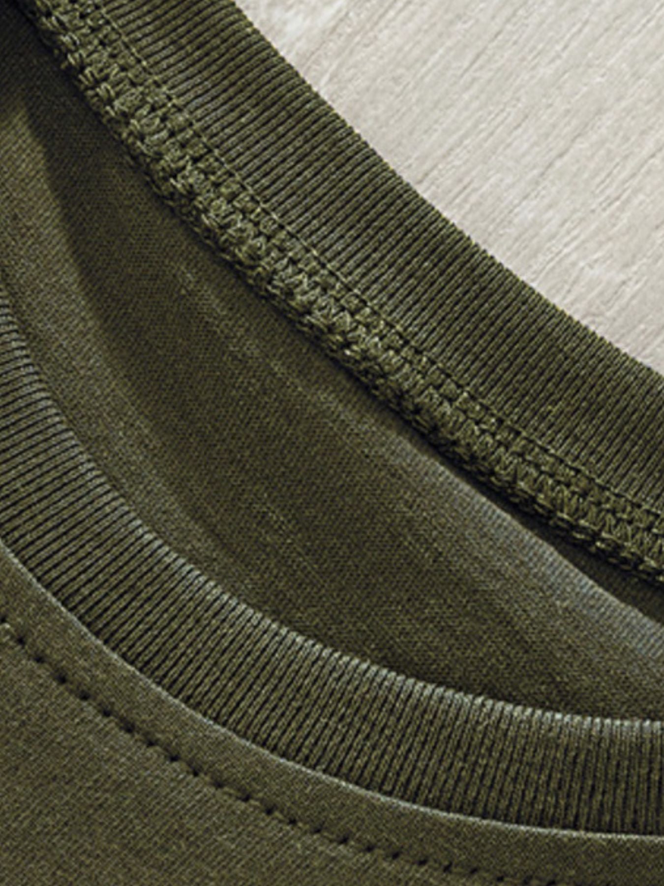 Close-up of the ribbed crew neckline and stitching on an army green children's T-shirt