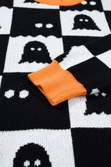 Close up of an orange ribbed cuff on a black and white ghost checkerboard sweater