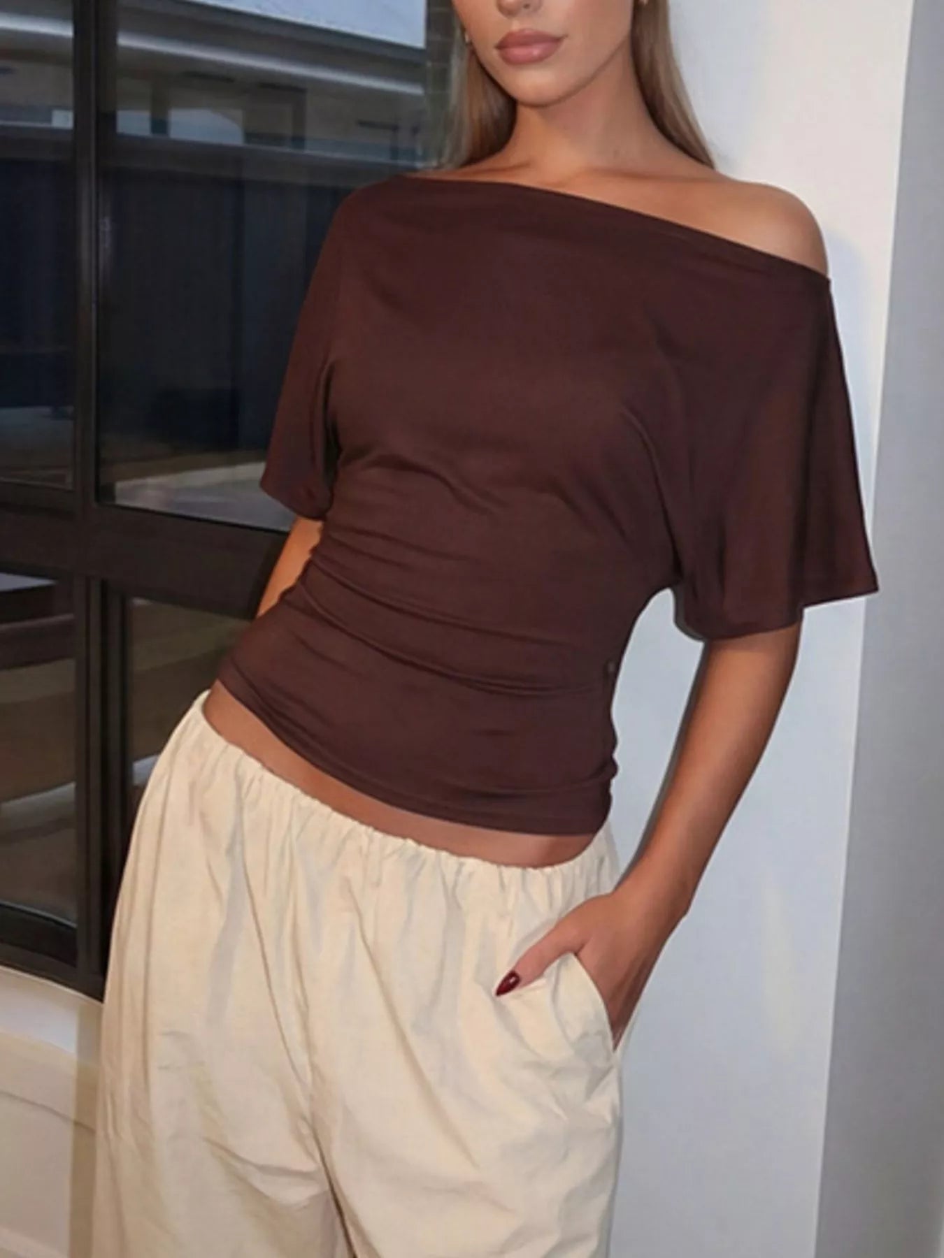 Brown boat-neck short-sleeve T-shirt shown on a model with cream drawstring pants.