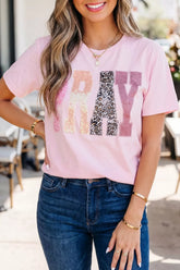 Pink PRAY graphic tee with sequin and leopard-print patchwork lettering, modeled with jeans
