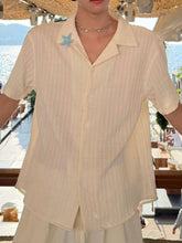 Men's textured short-sleeve shirt with buttons and a starfish brooch.