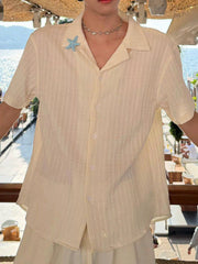 Men's textured short-sleeve shirt with buttons and a starfish brooch.