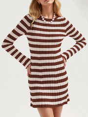 Brown striped ribbed knit long sleeve sweater dress in a front view with hands on hips