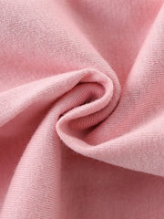 Close-up of soft folded blush pink knit fabric texture of children's short sleeve t-shirt