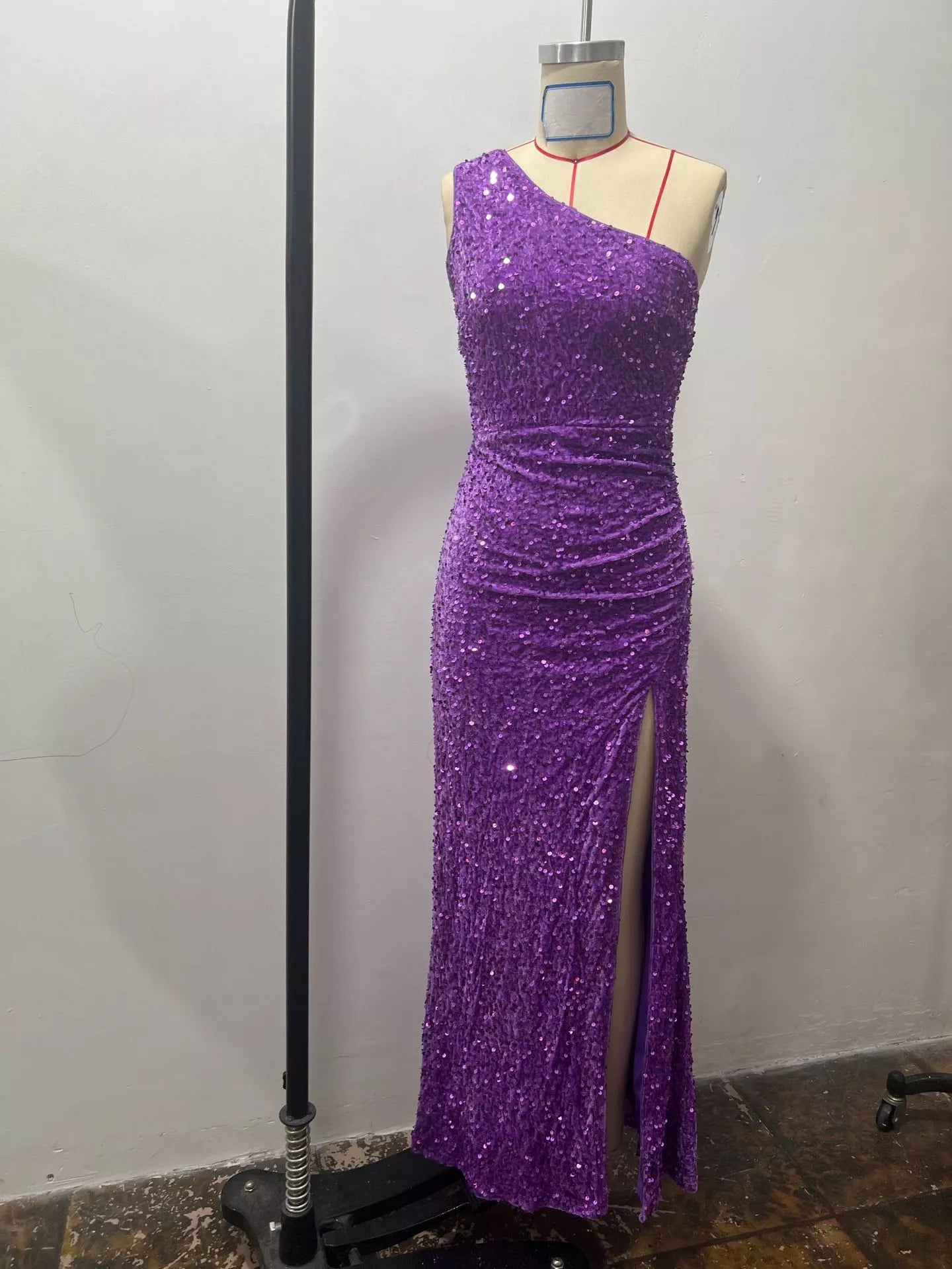 Purple sequin one shoulder evening dress front view on a dress form in a studio setting