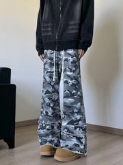 Men's grey camouflage wide leg jeans with white drawstrings and frayed raw hems, front view on model.