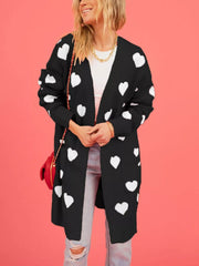 Front view of a black longline cardigan with white hearts worn open