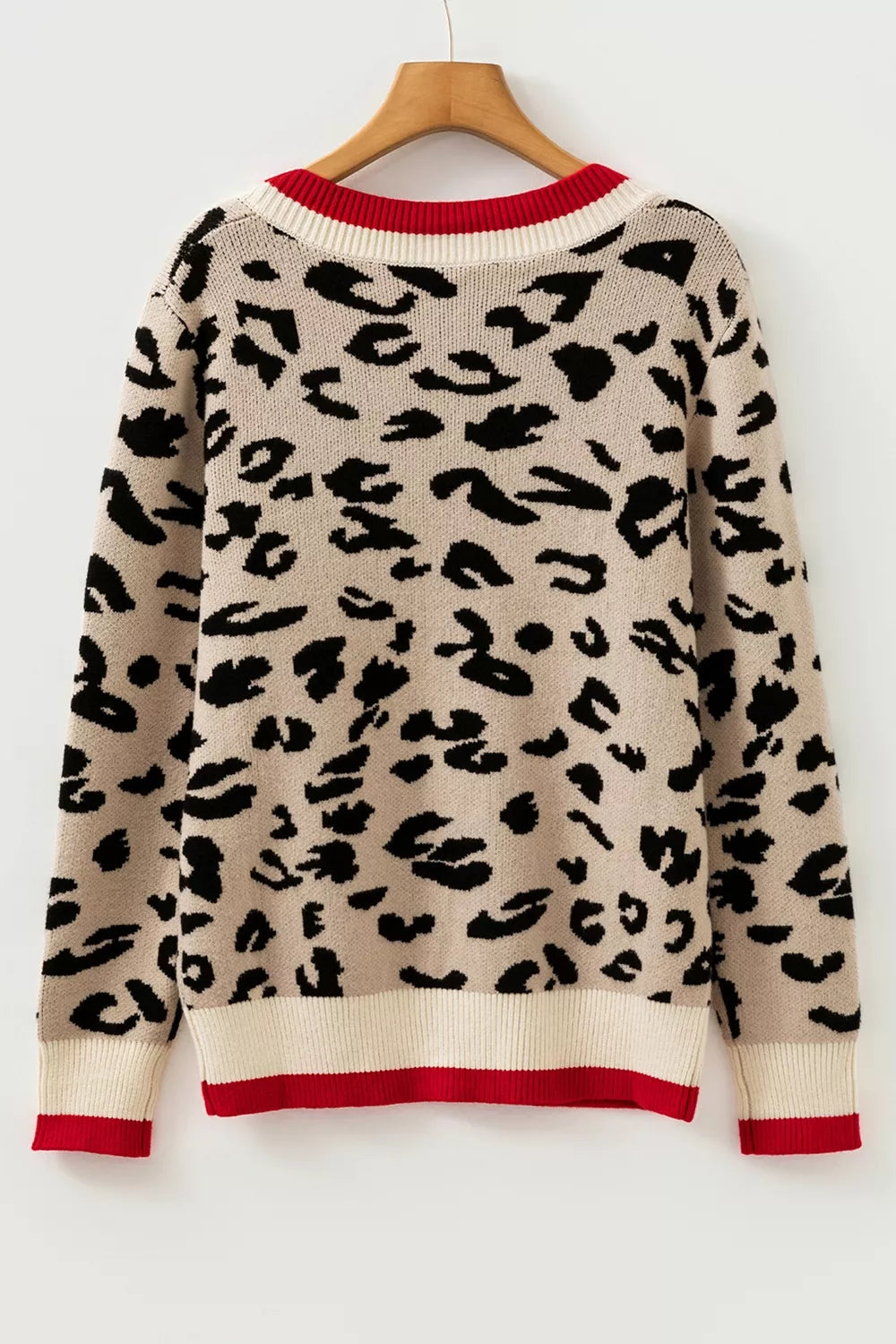 Back view of beige leopard print knit sweater with red and cream trim on a hanger.