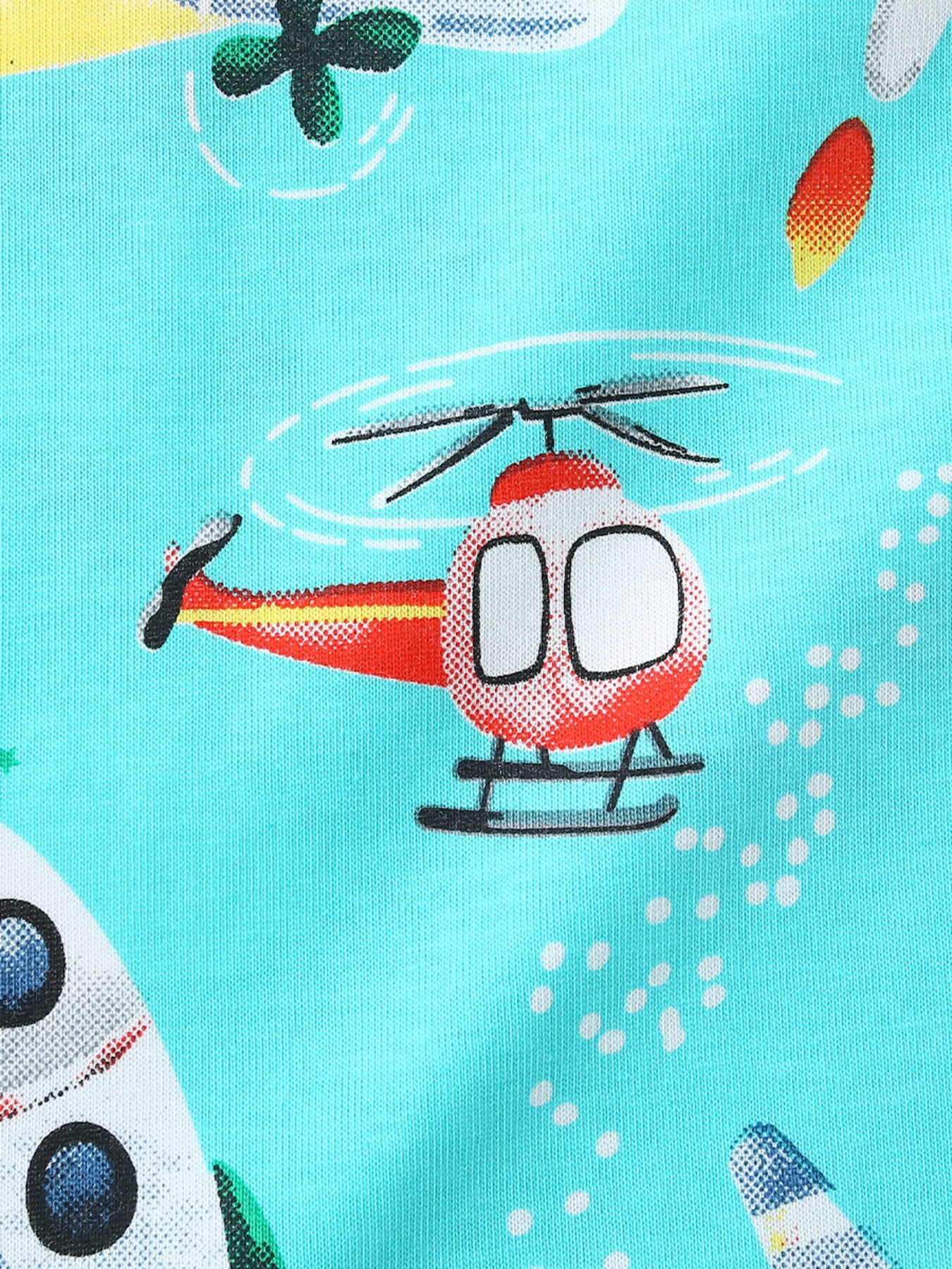 Close-up print detail of a red helicopter and part of a rocket on aqua fabric