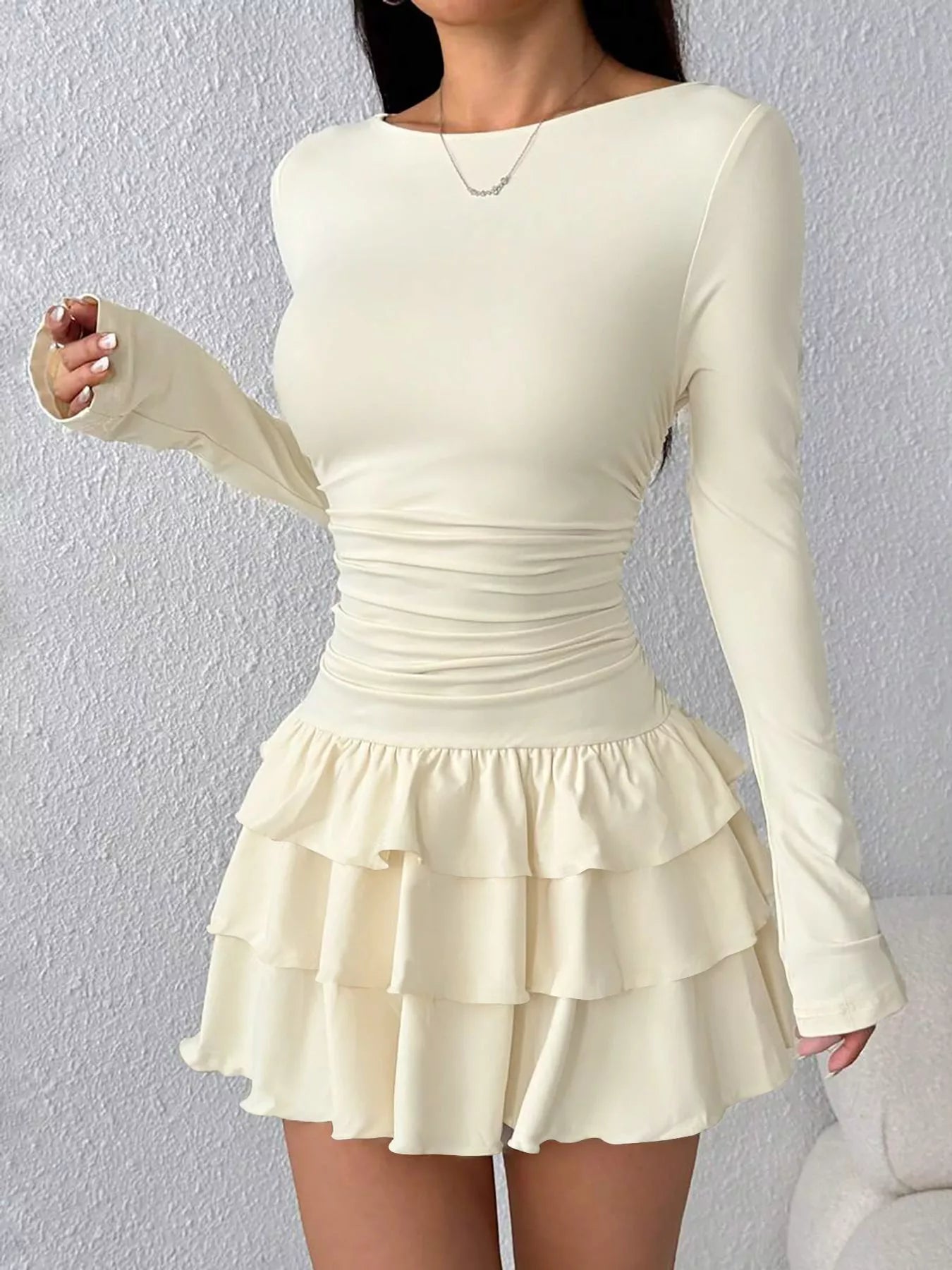 Apricot layered ruffle long sleeve mini dress worn front facing with ruched waist