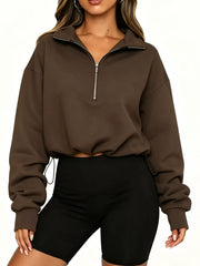 Front view of brown half zip sweatshirt with arms relaxed and drawstring hem