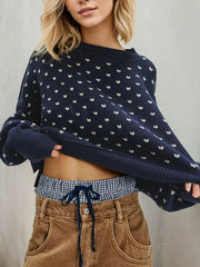 Navy dotted knit sweater with ribbed trim shown from the front as the model holds its hem