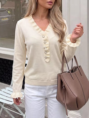 Cream ruffle trim V neck knit top with pearl buttons worn outdoors with tote