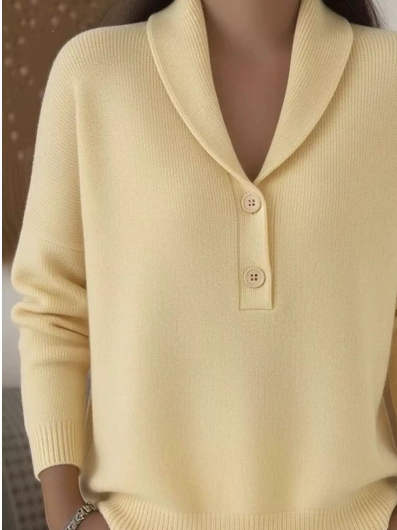 Closer on-model front view of the pale yellow shawl collar sweater with button placket