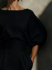 Close view of black puff sleeve midi dress bodice with round neckline