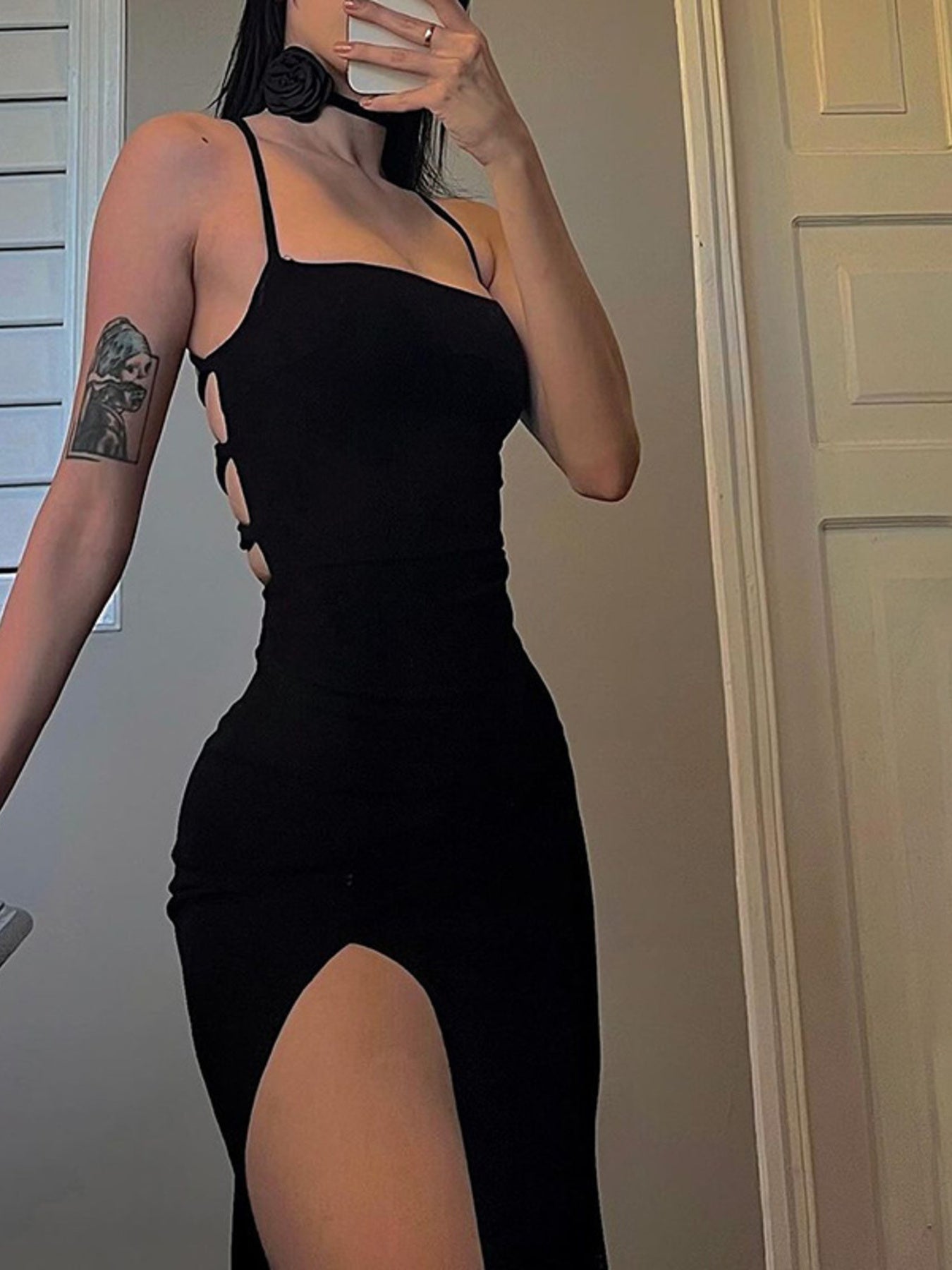 Black halter neck bodycon dress with side tie cutouts and high slit in a mirror selfie