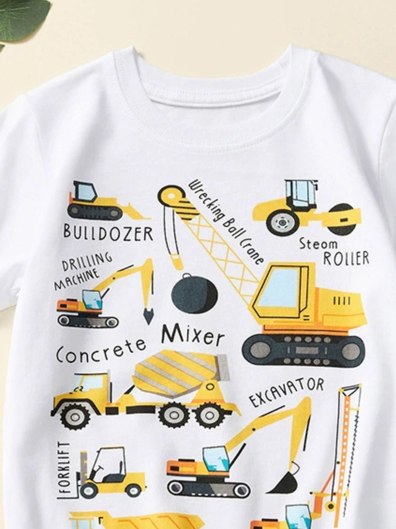 Close-up of the white crew neckline and upper construction vehicle graphics on a children's T-shirt