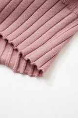 Close-up of the scalloped ribbed hem on a dusty pink knit cardigan