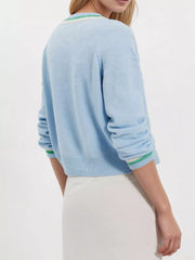 Back view on-model of light blue button down cardigan with green and cream striped cuffs