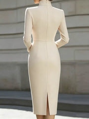 Back view of pale apricot stand collar long sleeve midi dress with back slit outdoors