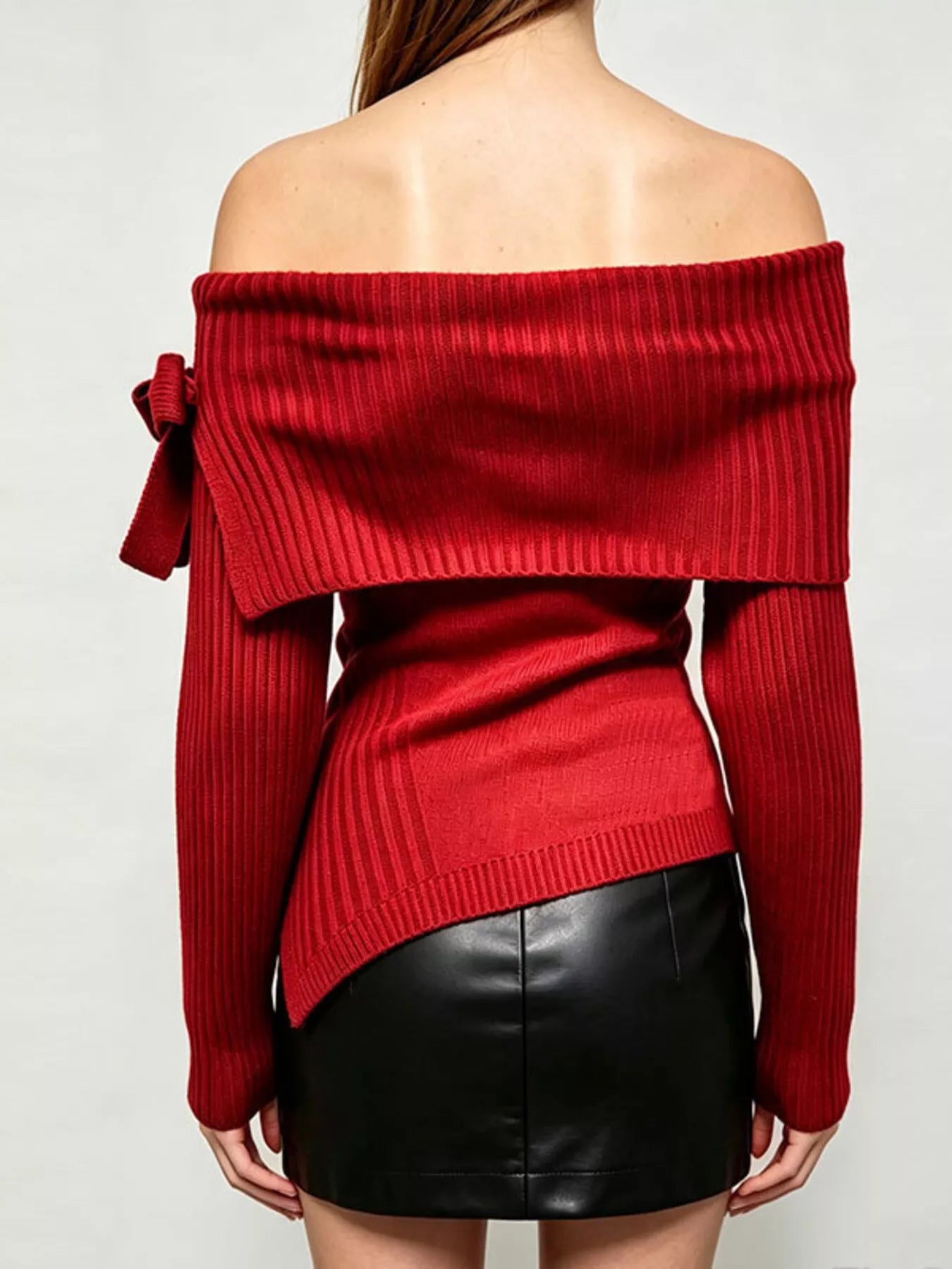 Back view of red off shoulder ribbed knit top with wide neckline and asymmetric hem