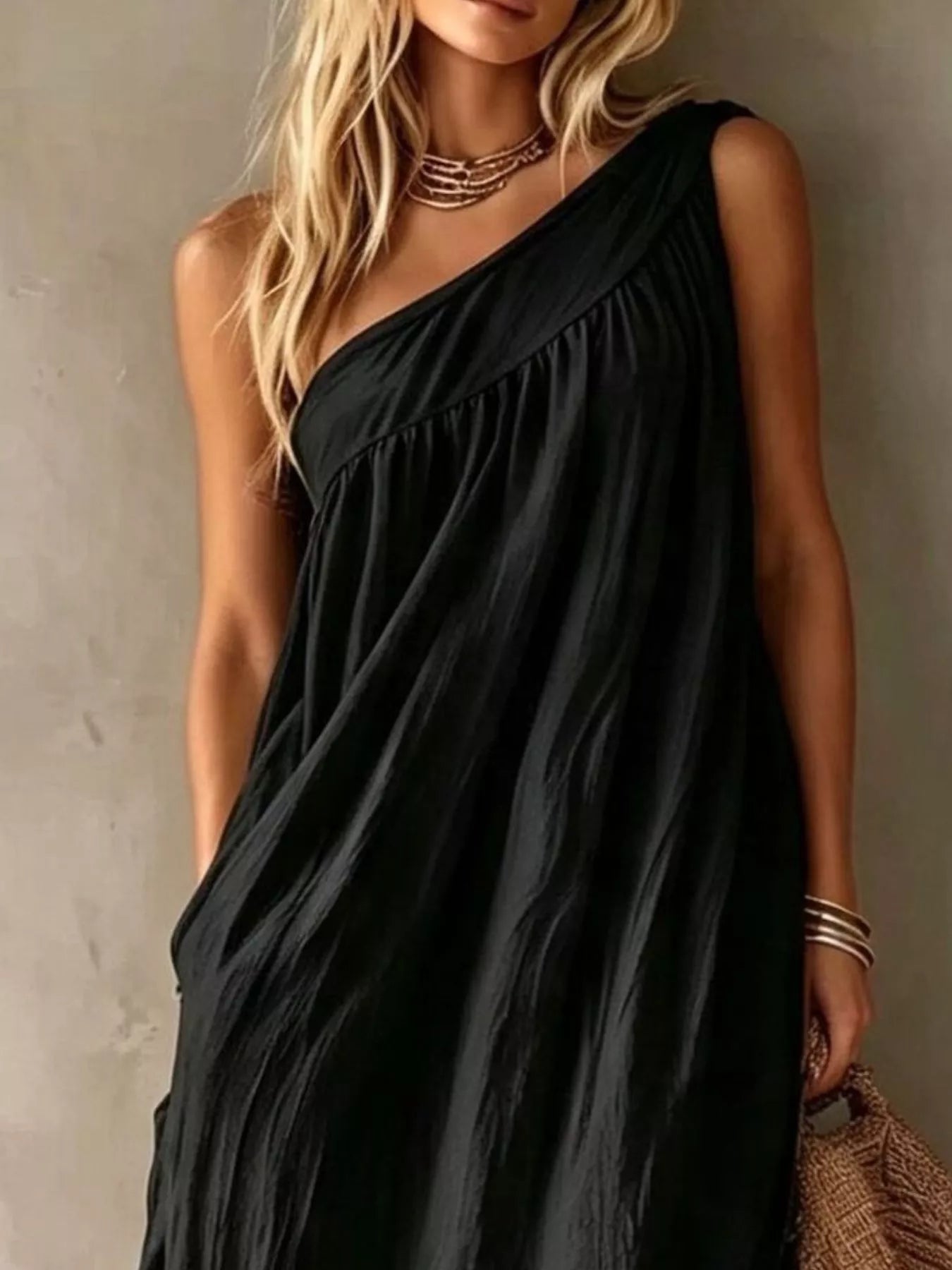 Close view of a black one shoulder maxi dress showing the gathered bodice and neckline
