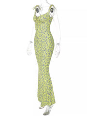 Side angle of clear mannequin wearing yellow floral print bodycon maxi dress with tie straps