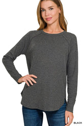 Women's black waffle-knit long-sleeve top with a crew neckline and rounded hem.