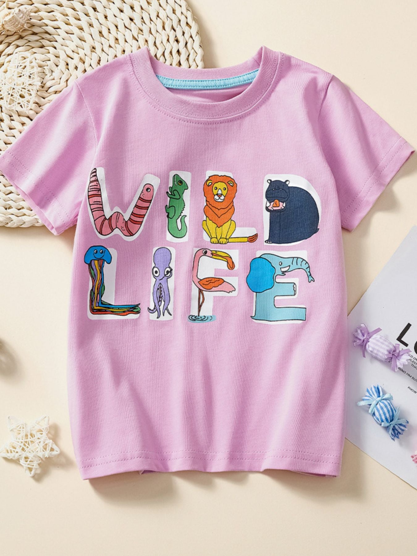 Flat lay front view of dusty pink children's T-shirt with animal letters spelling wild life