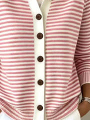 Close-up of the lower front and ribbed hem of a pink and white striped knit cardigan