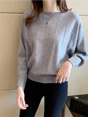 Front view of a gray batwing sleeve knit top with vertical seams and ribbed hem.