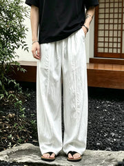 Men's wide-leg pants with a drawstring waist and pockets in the white color.