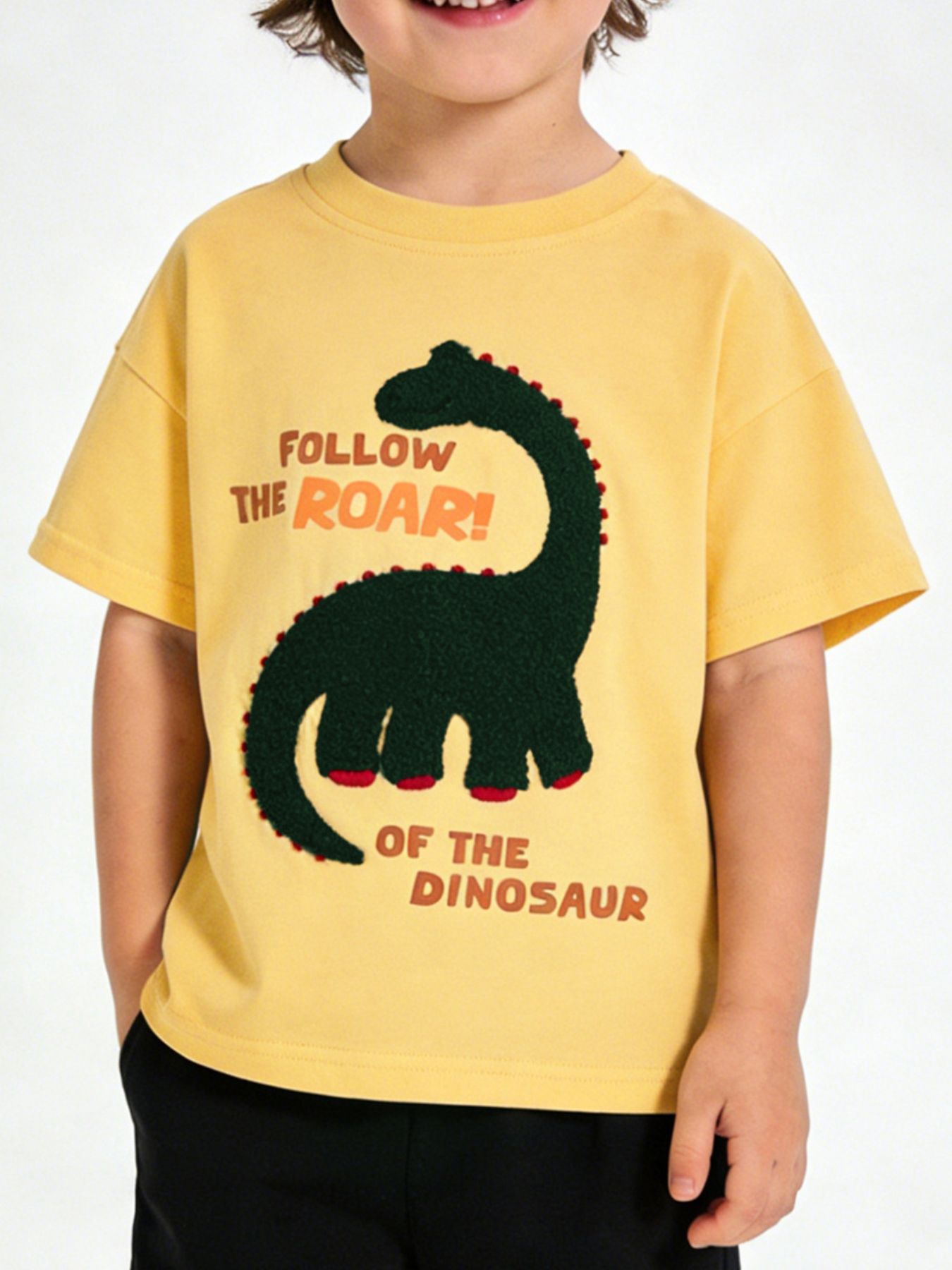 Children's yellow round neck T-shirt with a dark green textured dinosaur graphic, shown worn in front view