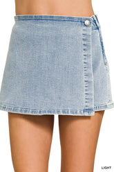 Women's light-wash denim skort with a wrap front and asymmetrical hemline.